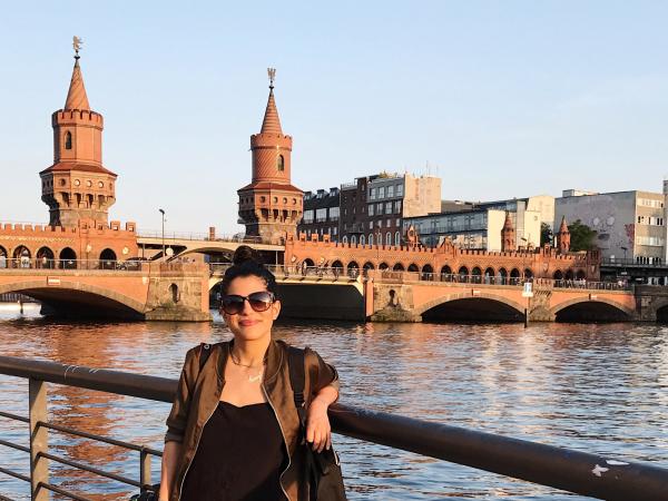 Woman standing on bridge overlooking urban river